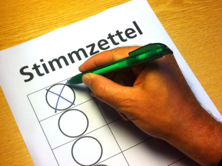 Bild © Amt für Stadtforschung und Statistik / Stadt Nürnberg Foto von einem Stimm·zettel. Eine Hand hält einen Kugel·schreiber. Auf dem Stimm·zettel ist ein Kästchen angekreuzt., Bild © Amt für Stadtforschung und Statistik / Stadt Nürnberg