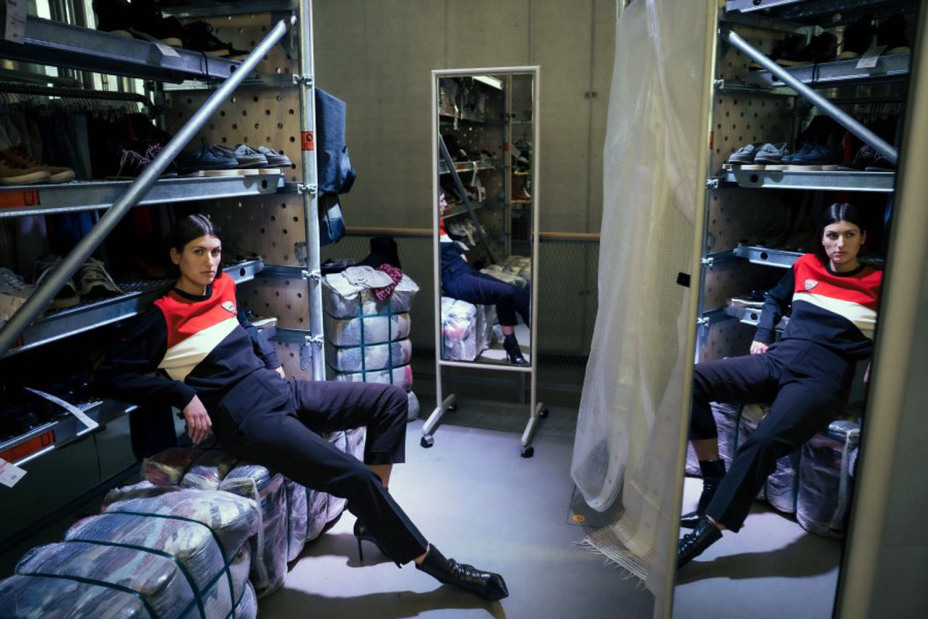 Ein Fotomodel posiert in einer Gebrauchtkleiderkammer.