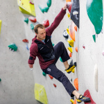 Foto: Para Kletterer Kevin Bartke beim erklimmen der Kletterwand in einer Boulderhalle.