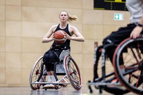 Foto: Rollstuhlbasketballerin Lilly Sellak kurz vor der Ballabgabe an eine Mitspielerin. © Daniel Karmann