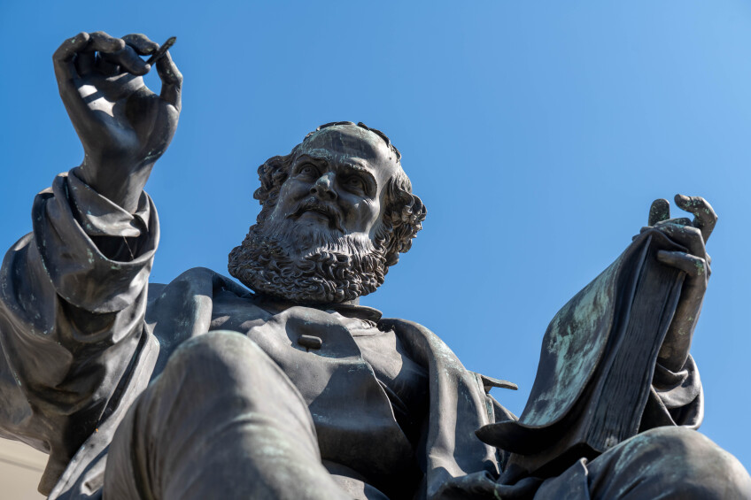 Foto: Denkmal von Hans Sachs. In seiner rechten Hand hält er einen Stift in der linken ein Buch., Bild © Stadt Nürnberg / Christine Dierenbach