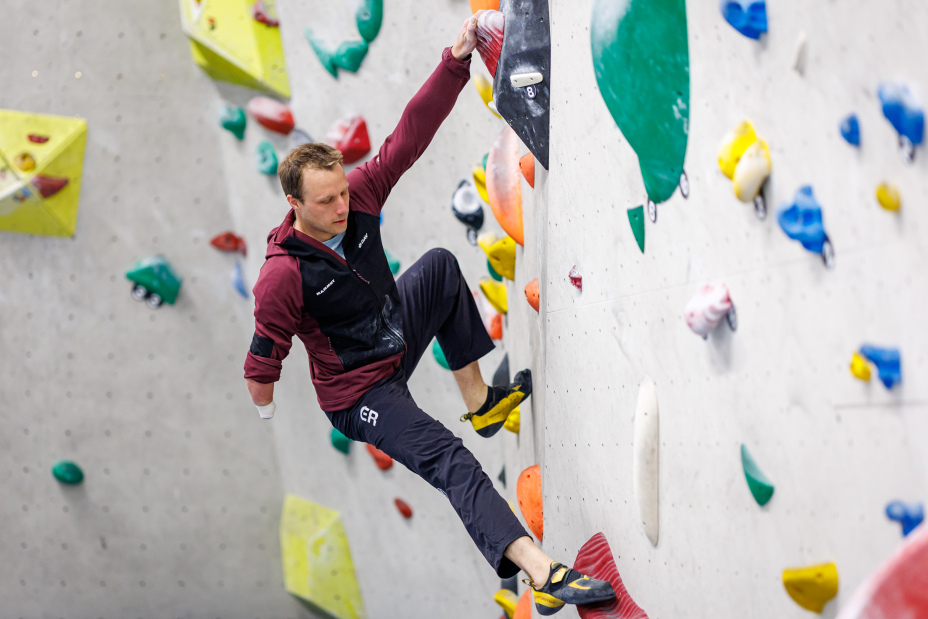 Foto: Para Kletterer Kevin Bartke beim erklimmen der Kletterwand in einer Boulderhalle.
