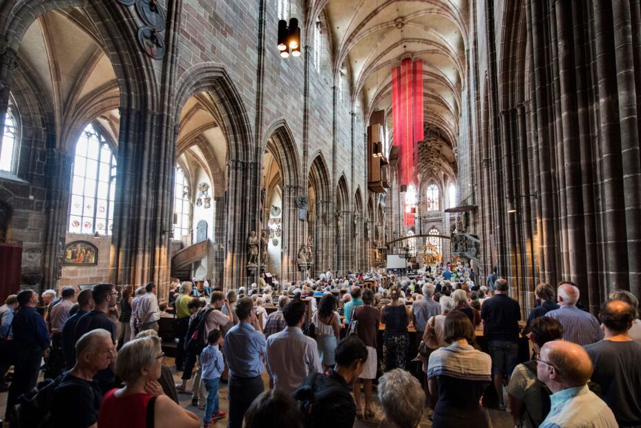 Foto: Innenraum der gotischen Lorenzkirche. Von hinten in den Bankreihen und stehend dahinter sehr viele Menschen., Bild © St. Lorenz Nürnberg