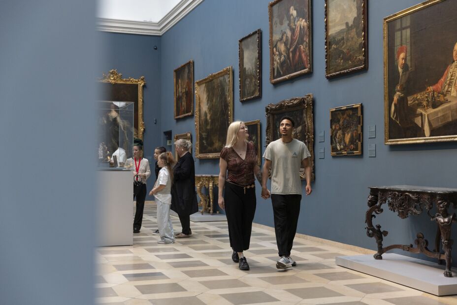 Foto: Saal eines Museums, an blauen Wänden hängen Gemälde, davor Besucherinnen und Besucher,, Bild © Germanisches Nationalmuseum/Felix Roeser