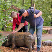 Ein Sehbehinderter ertastet eine Wildschweinskulptur