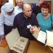 Leibl Rosenberg zeigt jüdischen Gästen Bücher, die während der NS-Zeit aus Wohnungen Nürnberger Juden entwendet wurden