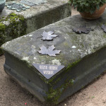 Epitaphienkünstler Thomas Haydn brachte die Namenstafel an einer abgebrochenen Ecke des Grabsteins an und ließ Ahornblätter aus Bronze auf den Steinquader herabsinken.