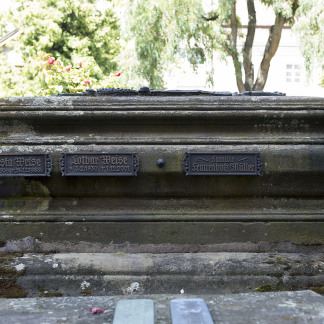 Wenn oben auf dem Grabstein kein weiteres Epitaph mehr hinpasst, findet sich an den Seiten Platz für die bronzenen Namenstafeln der Verstorbenen.