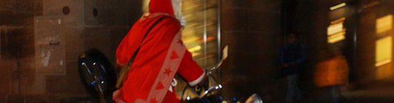 Ein Weihnachtsmann unterwegs auf seinem Fahrrad.