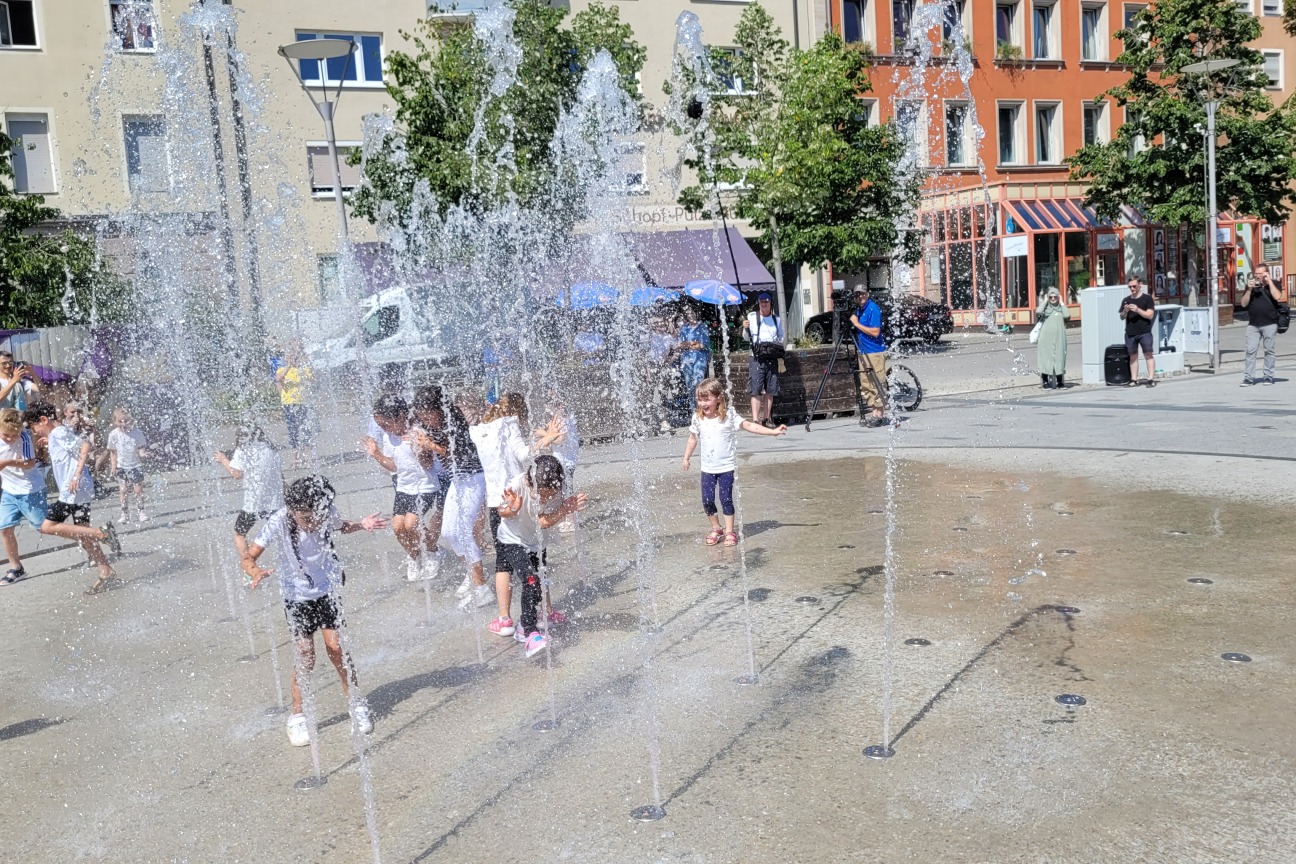 nach der Eröffnungsrede von Herrn OB König und dem Baureferenten Ullrich und einen fröhlichen Sommertanz der Kinder aus dem Kindergarten Südstadtsterne, stürmen die Kinder den Brunnen und erfreuen sich bei 33°C an dem kühlen Nass.