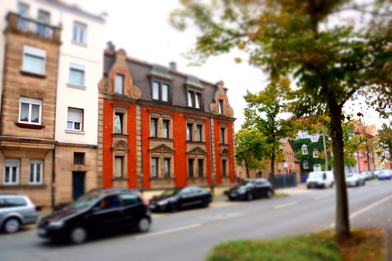 Straßenblick mit einem roten Gebäude im Vordergrund, Bild © decide