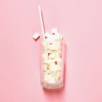 Ein Getränkeglas gefüllt mit Zuckerwürfeln und einem Strohhalm