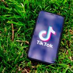 Handy mit TikTok App liegt auf einer Wiese