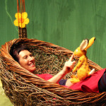 Schauspielerin sitzt in einem Korb mit Stofftierhasen