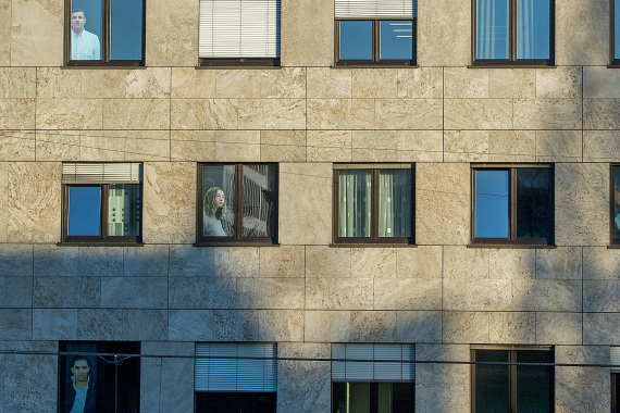 Figuren von Meschen in Fenstern eines Gebäudes