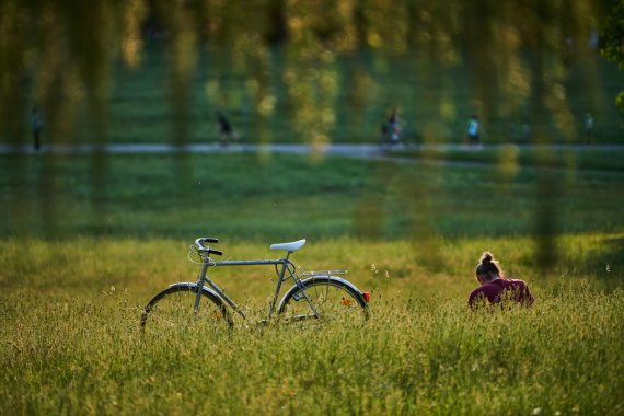 Blick auf eine sitzende Person mit Fahrrad