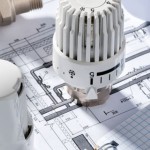 Energiesparen Konzept: Symbolbild mit Thermostat, Plänen und Sc