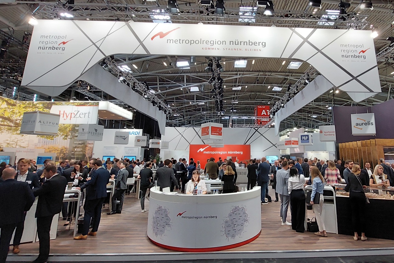 Interessierte unterhalten sich am Gemeinschaftsstand der Metropolregion Nürnberg auf der Immobilienmesse EXPO REAL., Bild © Wirtschaftsförderung Nürnberg