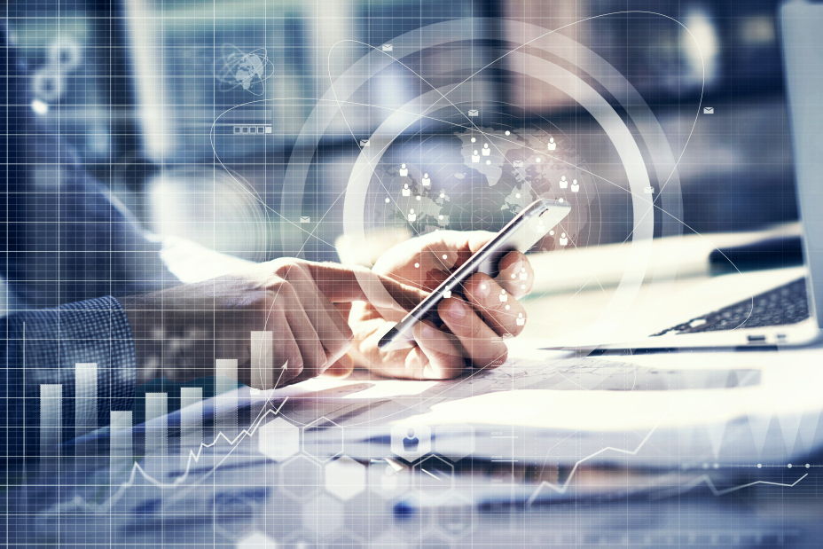 Eine Person hält ein Smartphone in der Hand und tippt darauf, während daneben ein geöffnetes Laptop steht; darüber liegen transparente digitale Grafiken wie globale Netzwerke, Diagramme und Symbole, die Digitalisierung und Beratung darstellen.