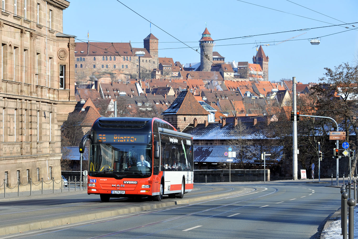 Hybridbus fährt entlang des Spittlertorgrabens, im Hintergrund sieht man die Burg.