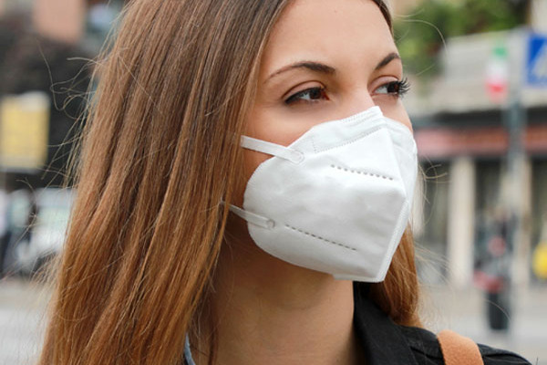 Frau mit FFP2 Maske auf der Strasse.