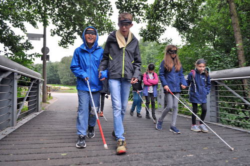 Dunkelerfahrungen auf dem Erfahrungsfeld: Kinder gehen mit Augenbinden und Blindenstöcken. © Olga Komarova / Stadt Nürnberg
