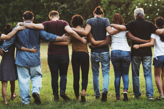 Group of friends huddle in rear view together