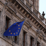 Eine EU-Flagge hängt am Rathaus und weht im Wind.