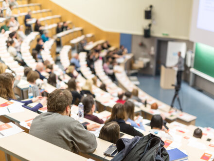 Bild © Matej Kastelic / AdobeStock Foto: Ein Hör·saal in einer Universität. In dem Hör·saal sitzen viele Personen und hören zu., Bild © Matej Kastelic / AdobeStock