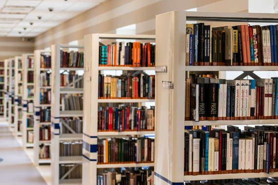 Bücherregale in einer Bibliothek, daneben ein Gang.