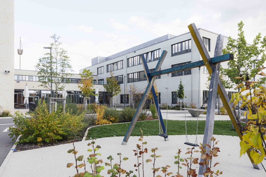 Schulhof des Schulcampus Werderau in der Maiacher Straße im Oktober 2025 mit Schaukel im Vordergrund und Schulgebäuden im Hintergrund., Bild © Giulia Iannicelli