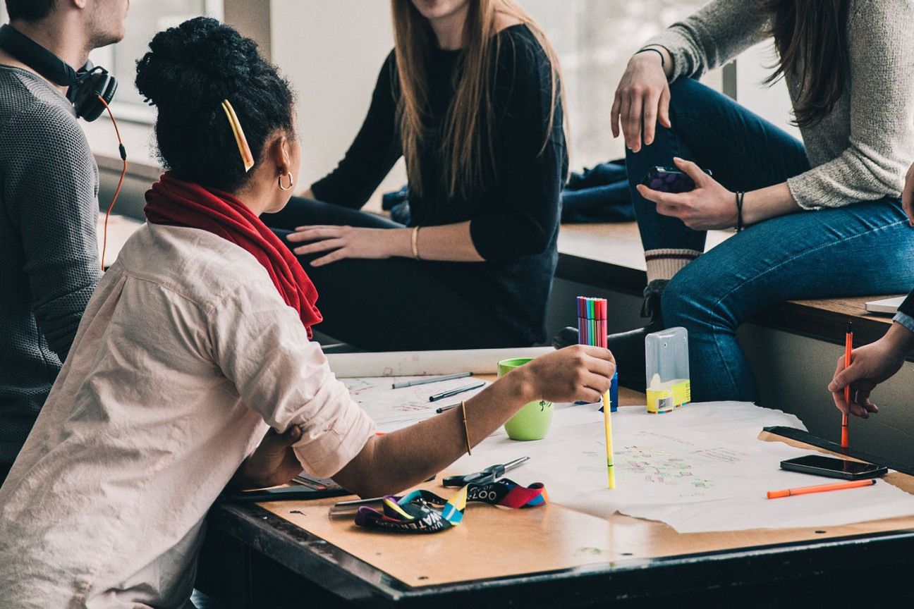 Junge Menschen um einen Tisch bei einer Besprechung, Bild © pixabay