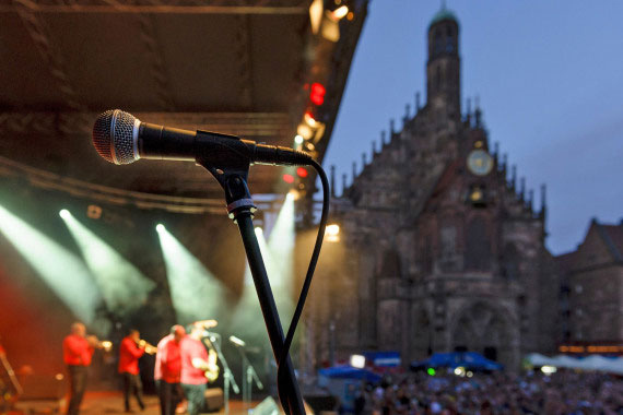 Ein Mikrofon steht auf einer großen Bühne, im Hintergrund die Frauenkirche auf dem Hauptmarkt