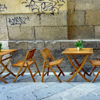 Tische und Stühle eines Straßencafés.