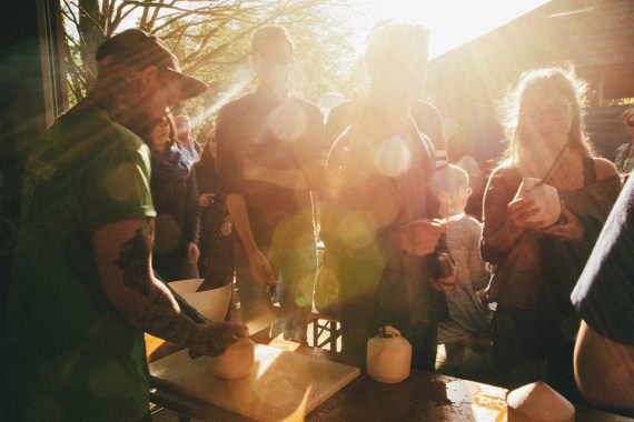 Menschen trinken an einem Foodtruck aus Kokosnüssen.