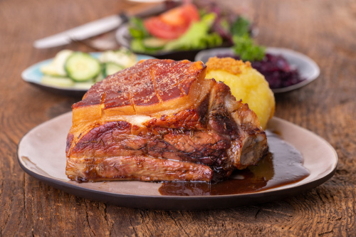 Ein Teller mit gegrilltem fränkischem Schäufele, Kloß und Soße.