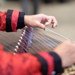 Zwei Haende spielen das chinesische Instrument Gusheng.