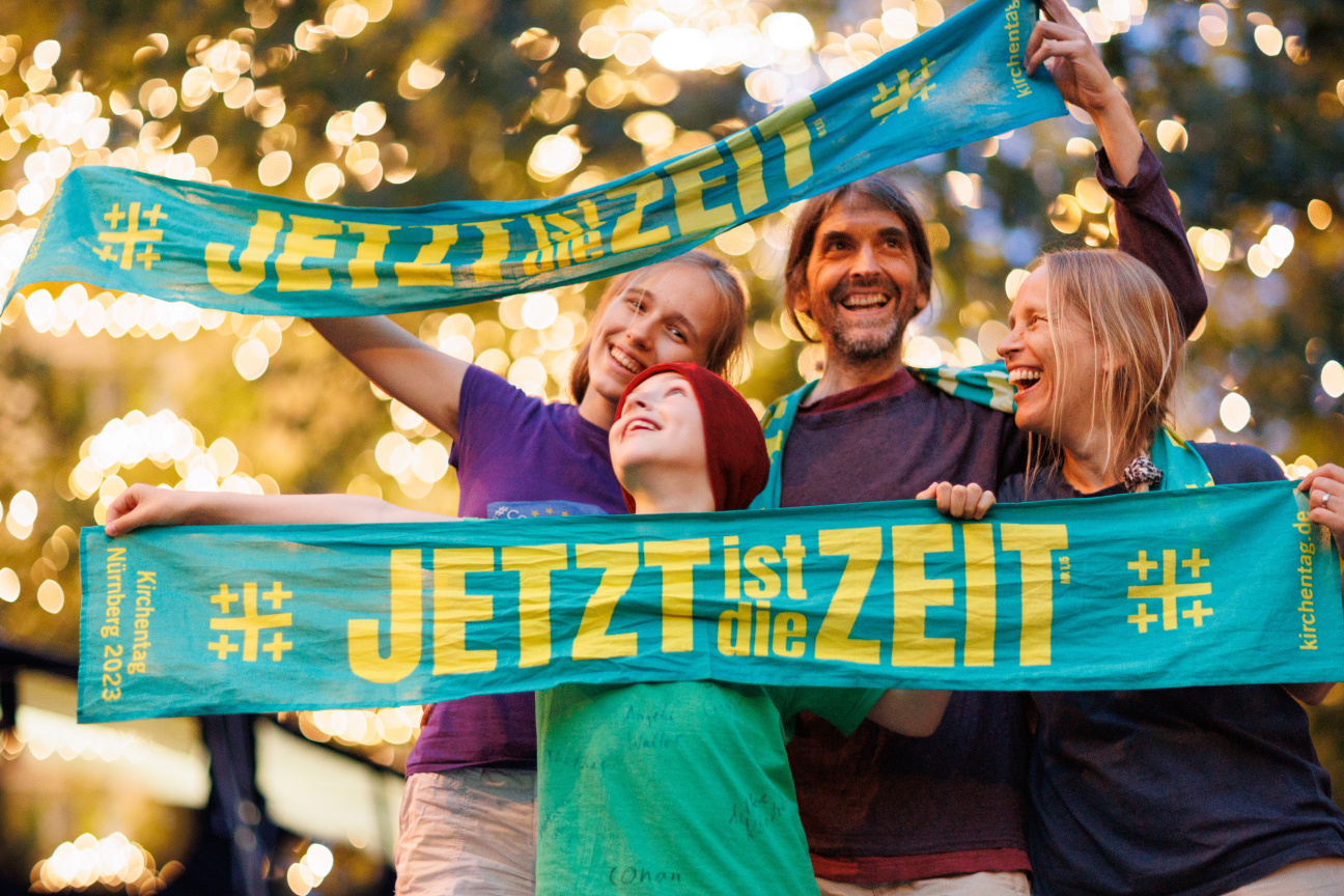 Eine Familie feiert beim Segen zur Nacht am Eröffnungstag des 38. Kirchentags.