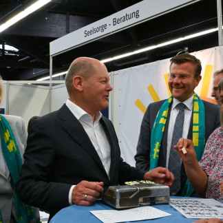 ( Bild: Christine Dierenbach / Stadt Nürnberg ) Bundeskanzler Olaf Scholz (2.v.l.), Kulturbürgermeisterin Julia Lehner (links) und Nürnbergs Oberbürgermeister Marcus König (2.v.r.) beim Rundgang durch die Messe.