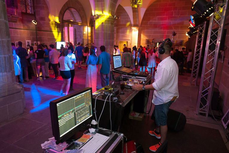 DJ mit DJ-Set und tanzende Menschen beim Rathausclubbing in der Ehrenhalle.