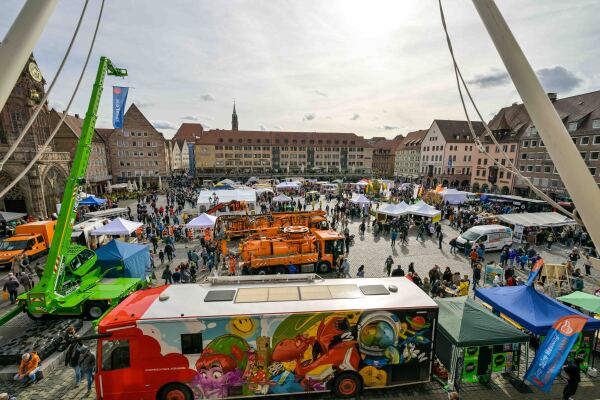 Blick auf den Hauptmarkt am Tag der offenen Tür 2024. Auf dem Platz verteilt sind Fahrzeuge und Zeltstände verschiedener Organisationen.