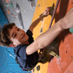 Junge klettert in einer Kletterhalle