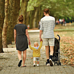 Eine Familie mit Kleinkind geht spazieren.