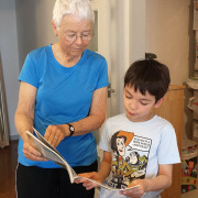 Oma schaut mit Enkel ein Buch an.