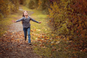 Ein Kind läuft durch Herbstlaub.