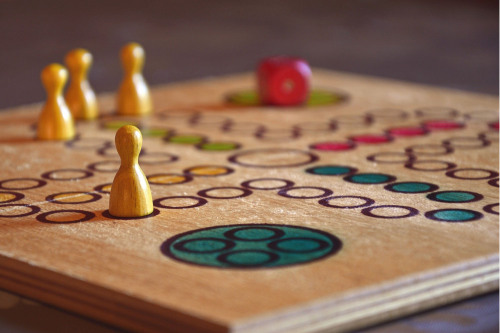 Steine und Würfel auf einem Brettspiel.