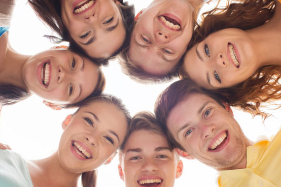 Einge Gruppe Jugendlicher steckt die Köpfe zusammen.