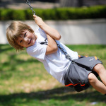 Junge schwingt auf einer Schaukel