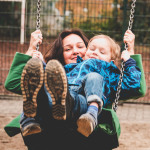 Eine Mutter schaukelt mit ihrem kleinen Kind.