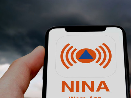 Ein Handy mit dem Zeichen von der NINA Warn-App., Bild © AdiobeStock
